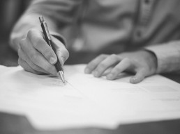Rechtsanwalt Prelinger Aufsätze - Hände schreiben auf Papier